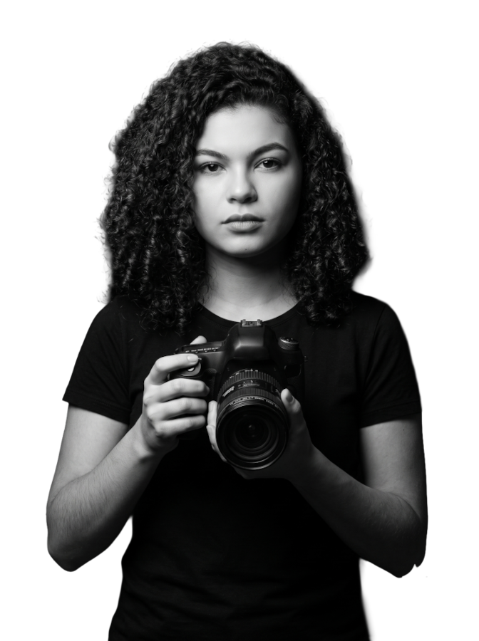 Retrato em preto e branco de Ellen segurando uma câmera contra um fundo escuro